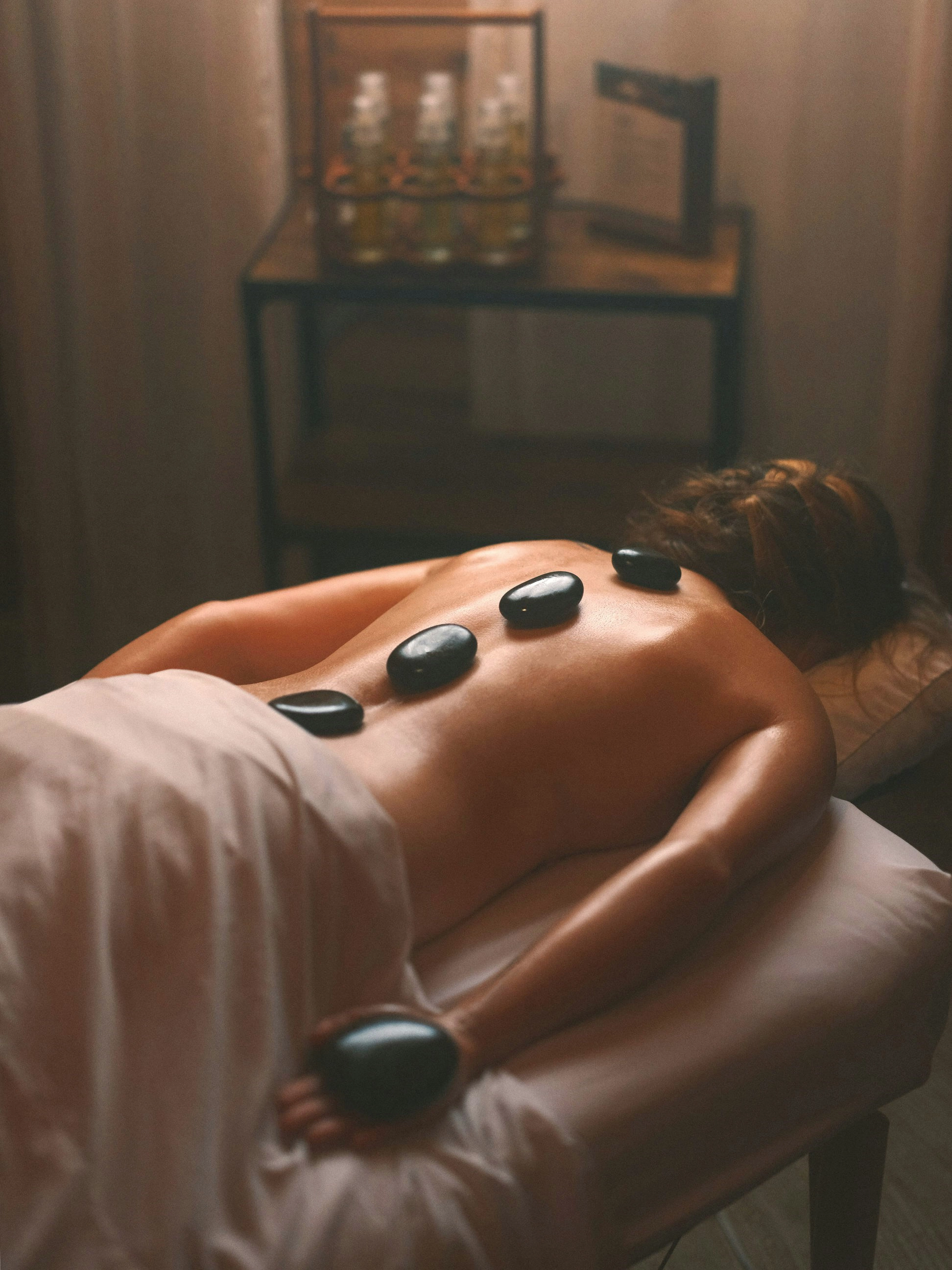 Image d'un massage aux pierres chaudes disposées sur le dos d'une femme